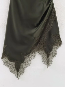 Detailed view of dark olive satin fabric with exquisite lace trim and irregular hemline