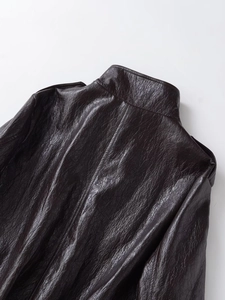 Close-up of textured faux leather jacket featuring stand collar and shoulder details