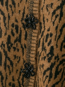Détail macro du tricot léopard et des boutons floraux perlés sur le cardigan pour femme