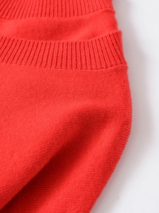 Close-up of red knit sweater neckline showing detailed ribbed texture and stitching