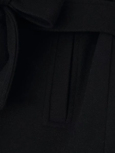 Detailed view of the side pocket and fabric texture on a black wool coat with waist belt