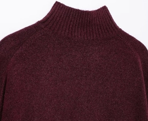 Detail of burgundy turtleneck sweater showing ribbed collar and fine knit texture