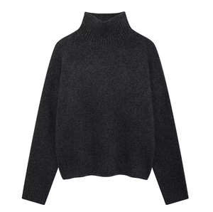 Detailed close-up of dark grey high-neck knit sweater showing ribbed cuffs and texture