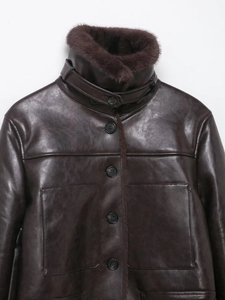 Detail of dark brown faux fur jacket with plush collar and premium leather texture