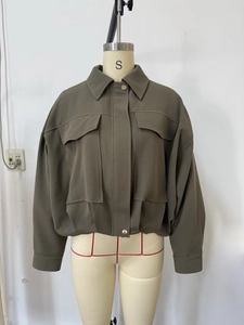 Vue détaillée du blouson aviateur vert foncé avec grandes poches et col à revers classique