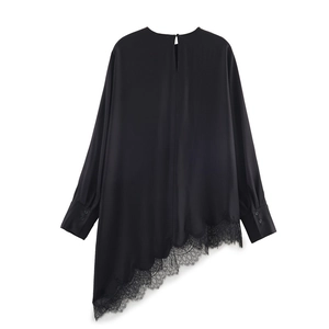 Detail view of the asymmetric hem with delicate floral black lace on a satin blouse