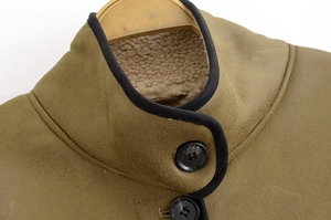 Detail of faux suede jacket with thick sherpa lining and black leather collar trim