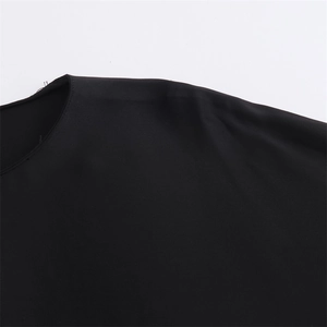 Close-up of black satin shirt detailing the round neckline stitching and shoulder drape