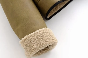 Detail of khaki faux suede jacket cuff with cream faux shearling lining and black piping