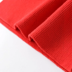 Close-up of bright red ribbed knit fabric texture on a loose pullover sweater