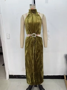 Dettaglio della fibbia a cuore con strass su un abito in velluto verde con ritagli