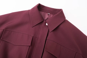 Vue détaillée de la veste bomber bordeaux avec poches à rabat et coutures fines