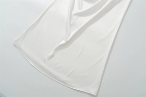 Detailed macro view of white silk fabric showing smooth satin texture and elegant drapes