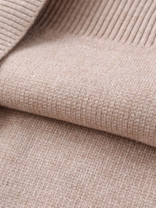 Close-up of premium light khaki knit fabric with detailed ribbing and soft wool texture