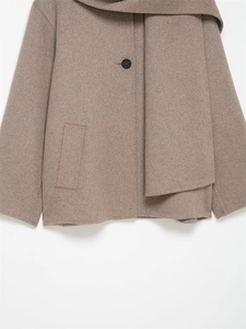 Detail view of camel wool blend jacket featuring an integrated scarf collar and black button