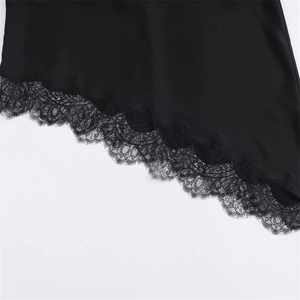 Close-up of elegant black dress hem featuring delicate eyelash lace trim and refined detail