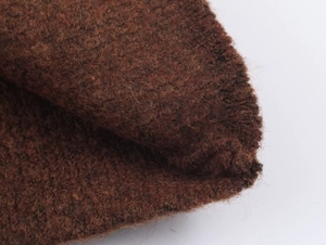 Close-up of thick coffee brown knit fabric showing soft wool fiber texture and weave details
