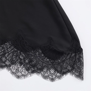 Close-up of elegant black floral eyelash lace trim on a minimalist solid shirt hem
