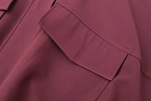 Détail de la poche à rabat de la veste bomber bordeaux et texture des coutures