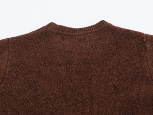 Detailed macro view of dark brown knitted sweater collar with ribbed trim and chunky texture
