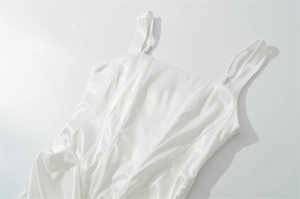 Detailed view of white satin dress featuring adjustable spaghetti straps and square neckline