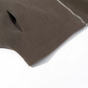 Detailed close-up of dark brown wool coat featuring a metal zipper and side pocket