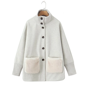 Detail of winter jacket featuring knit stand collar and large faux fur pockets
