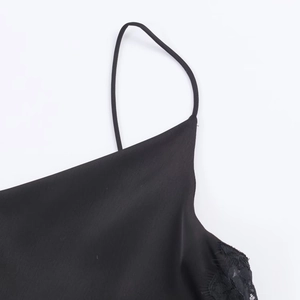 Detail of black silk satin slip dress featuring delicate lace trim and thin straps