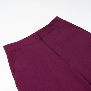 Detail of waist structure and stitching on dark burgundy high-waisted trousers