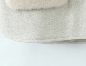 Close-up of wool fabric texture with beige plush trim and fine edge stitching