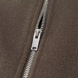 Detail of a premium silver metal zipper on a soft brown wool jacket close-up view