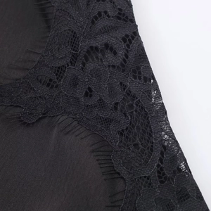 Detailed macro view of black satin fabric with delicate eyelash lace trim and stitching