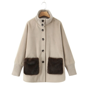 Detail of winter knit jacket with contrast brown faux fur pockets and tortoiseshell buttons