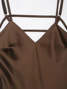 Detail of deep brown satin V-neck dress featuring sleek spaghetti straps and silky finish