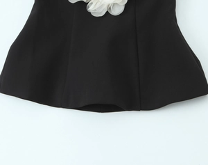 Detail of the white mesh floral applique on the neckline of a black strapless tube top