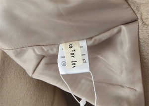 Detail view of khaki suede jacket lining with size S label and care instructions