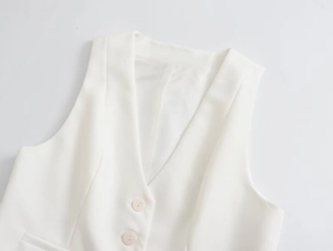 Détail rapproché d'un gilet sans manches blanc avec col en V, boutons blancs et doublure