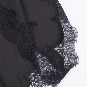 Detail of silk satin fabric with elegant black eyelash lace trim and floral patterns