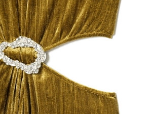 Dettaglio macro di un abito in velluto verde oliva con ritaglio e fibbia in strass