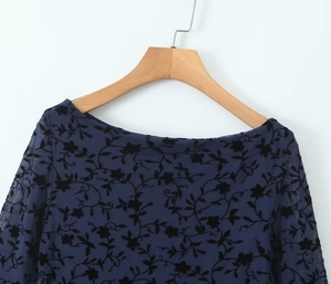 Detail view of navy blue mesh mini dress with black flocked floral pattern and off-shoulder cut