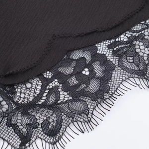 Close-up of black silk satin fabric with delicate floral eyelash lace stitching details