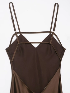 Detail of dark brown satin dress showing thin shoulder straps and V-neckline geometry