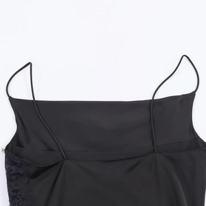 Close-up of black satin dress featuring delicate lace trim and thin shoulder straps