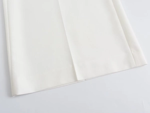 Détail du pantalon blanc à jambes larges montrant le tissu en sergé et le pli central