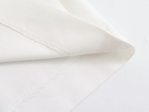 Vue macro détaillée du tissu blanc tissé avec couture surjetée et finitions soignées