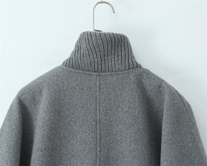 Detail of grey winter jacket featuring a high-neck ribbed knit collar and thick wool fabric