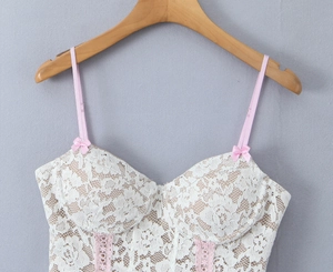 Close-up of floral lace bustier top with pink bow accents and satin shoulder straps