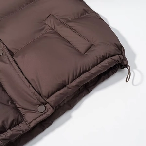 Detail of hooded jacket showing drawstring hem, large side pockets and snap buttons