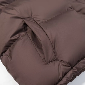Macro detail of the stitching and side pocket on a dark brown hooded cotton jacket
