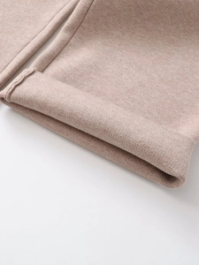 Close-up of ribbed cuffs on oatmeal knit sweatshirt and casual pants set fabric